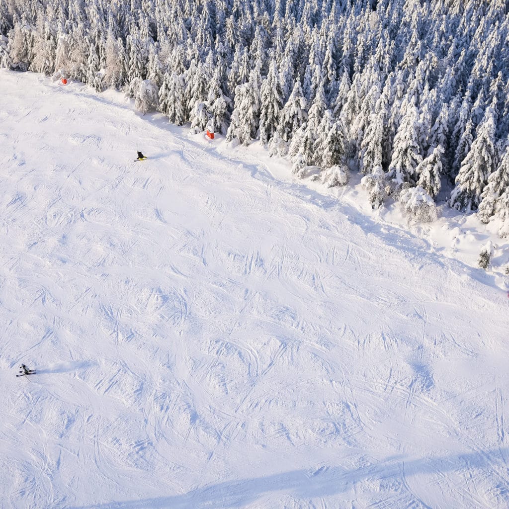 large ski slope with skiers from above picjumbo com